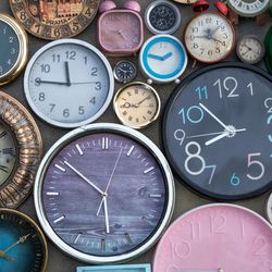 a wall filled with different time of clocks all with different times