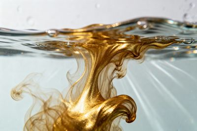 gold ink diffusing through some water
