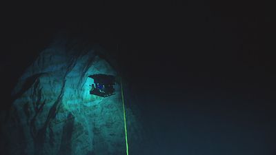 A remotely operated vehicle, Deep Discoverer, explores the Mariana Trench at a depth of 6,000 meters (3.7 miles).