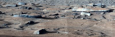 reddish and grey rocks are visible in the image with several smoothed by water