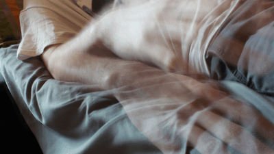 a man is lying on a bed looks like his ghost is leaving his body