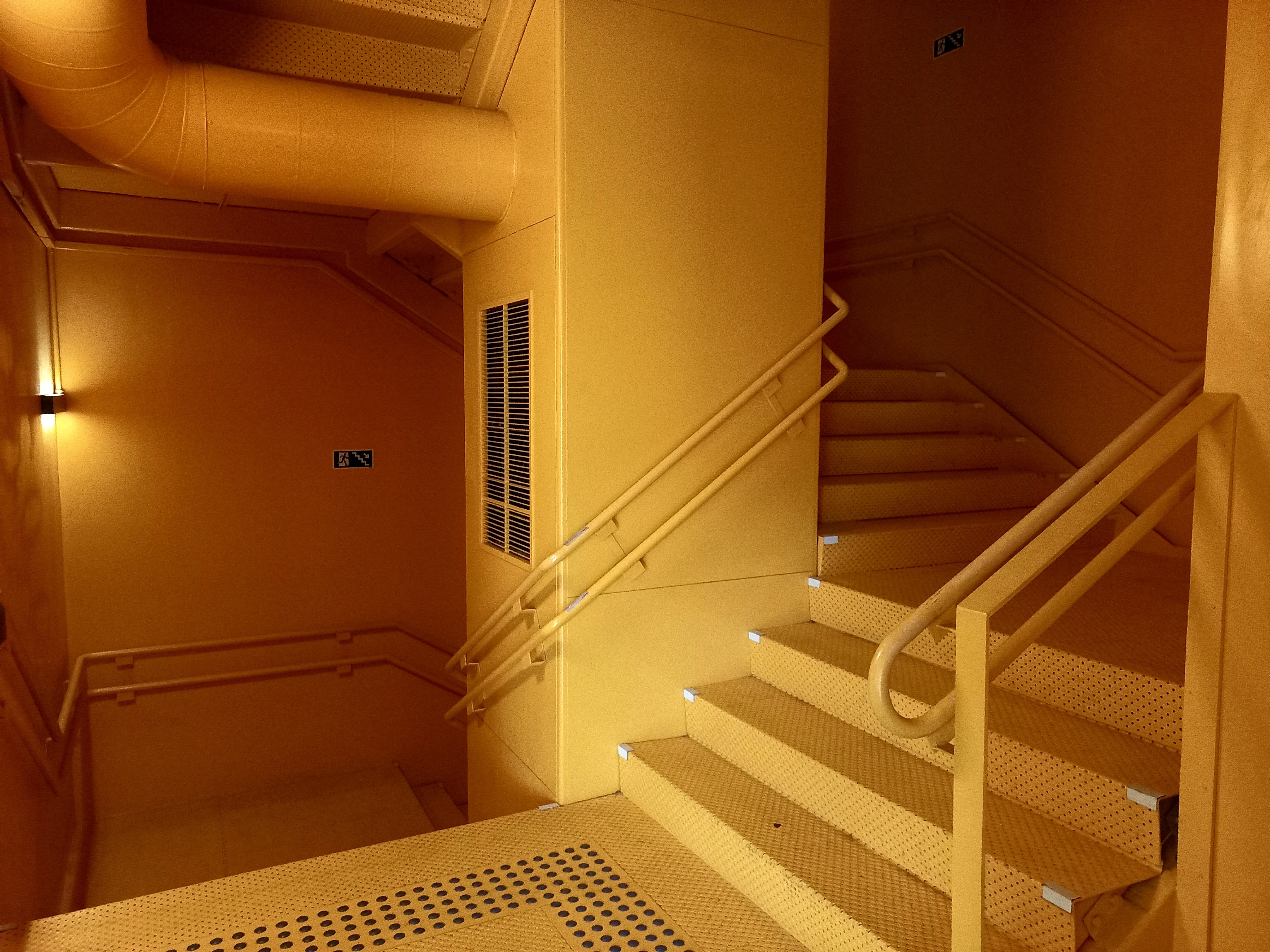 A twisting stairwell all painted in the same, yellow-orange colour. A twisting stairwell all painted in the same, yellow-orange colour.