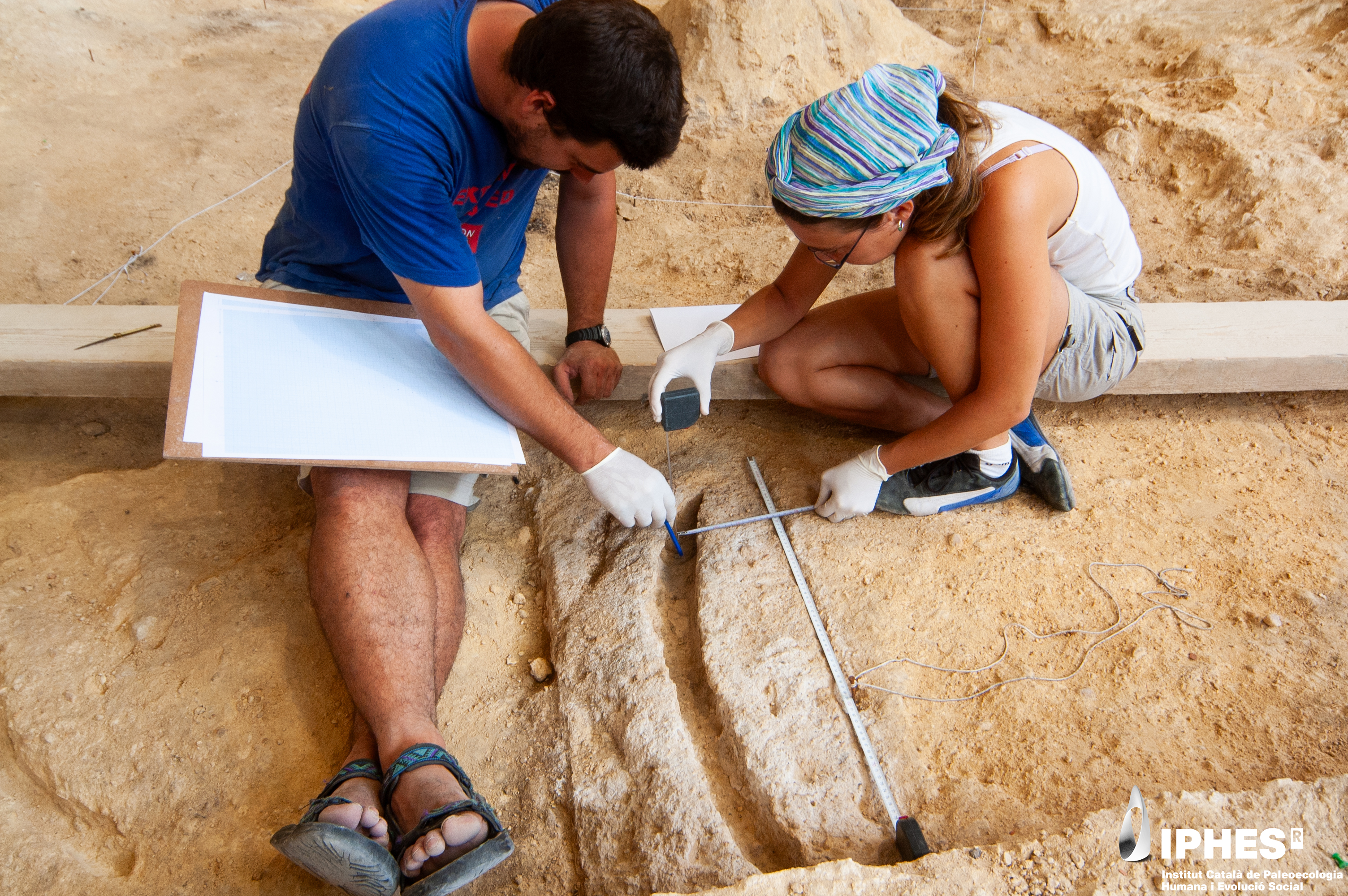 Researchers analyze the imprint of a wooden tool made by Neanderthals. Researchers analyze the imprint of a wooden tool made by Neanderthals.