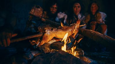 Prehistoric humans cooking meat