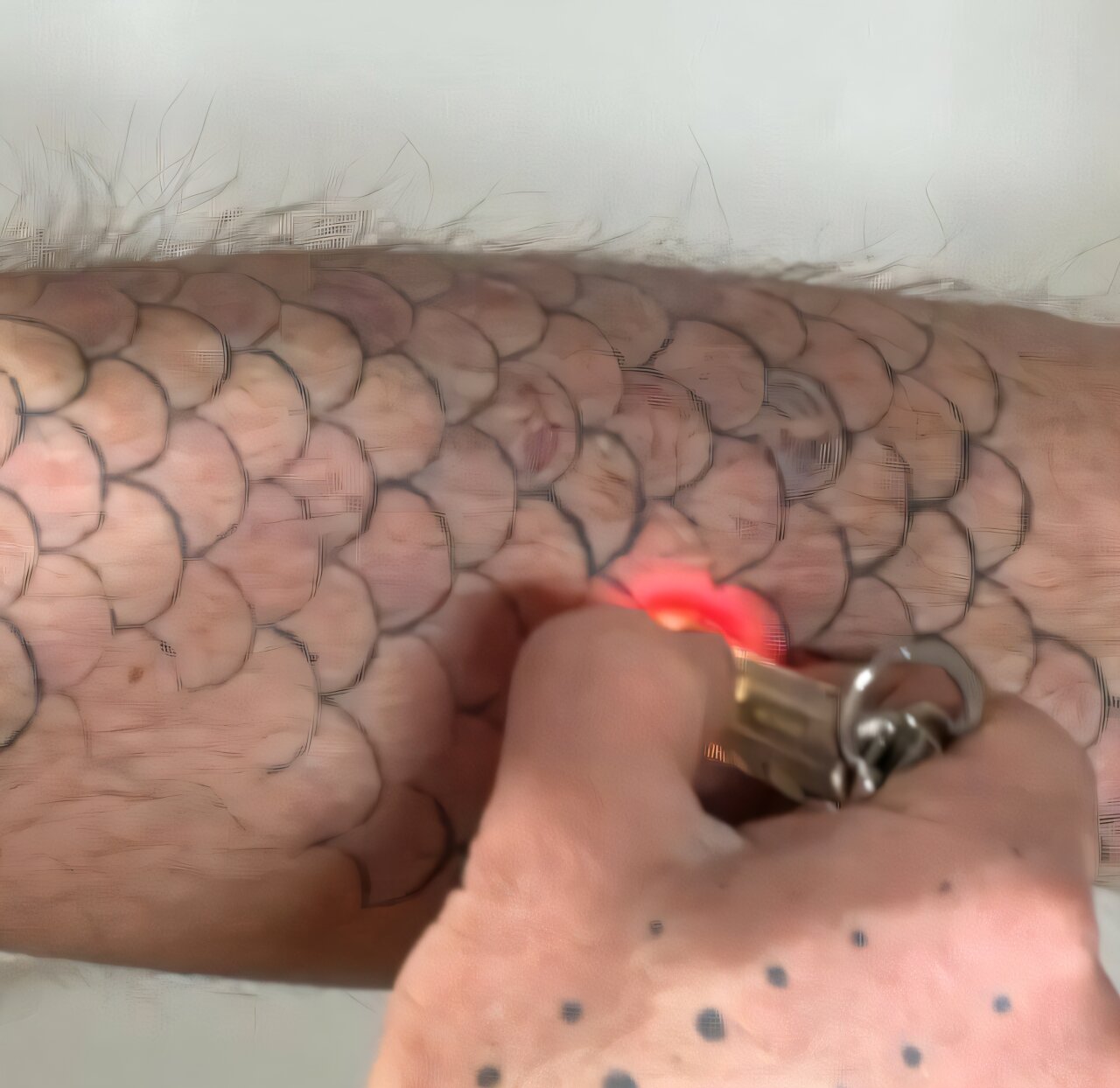 A leg with a fish scale tattoo being colored in with light. A leg with a fish scale tattoo being colored in with light.