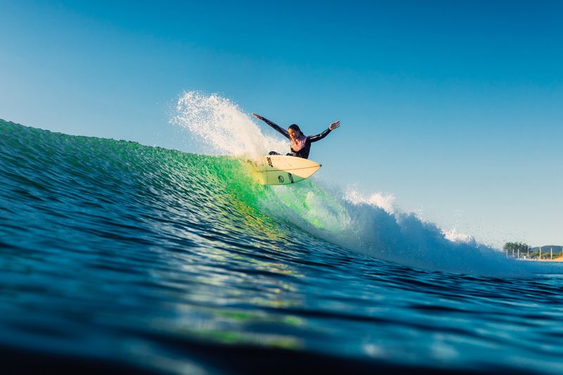 Woman during surfing with morning light. Surf girl on surfboard.