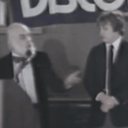 Three magicians standing on a stage.