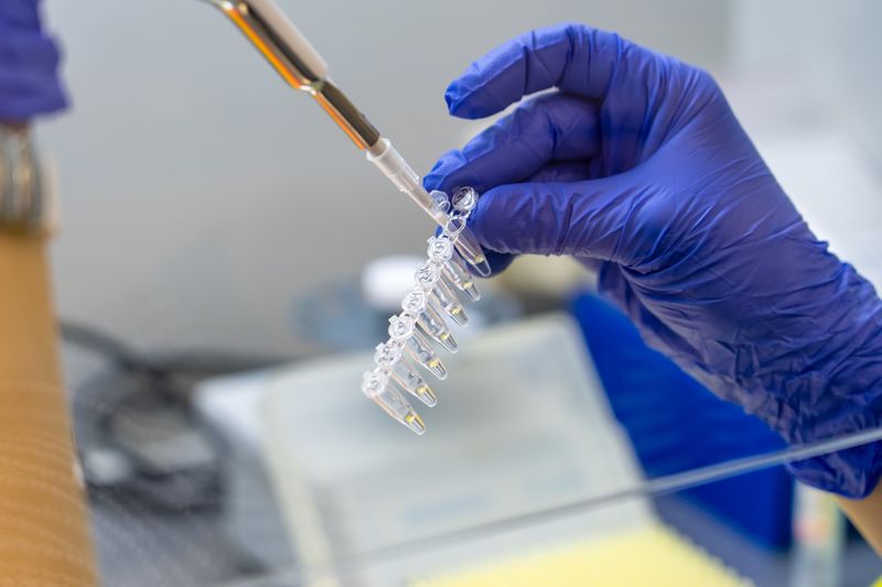 A person using a pipette to take samples.